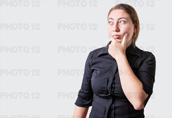 Young woman thinking with hand on chin isolated. Thoughtful beautiful girl with hand on chin isolated