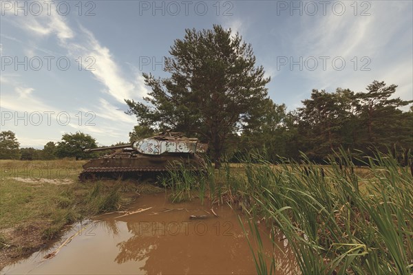 Abandoned tank stands in the middle of nature, silently reflected in the water of a pond, M41 Bulldog, Lost Place, Brander Wald, Aachen, North Rhine-Westphalia, Germany, Europe