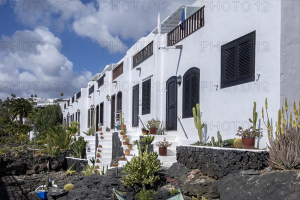 Typical white houses on the promenade, with small gardens on lava rock, Puerto del Carmen, Lanzarote, Canary Islands, Spain, Europe