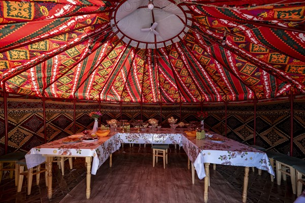 Set table and chairs in a colourful yurt, yurt with traditional patterns, Naryn region, Kyrgyzstan, Asia