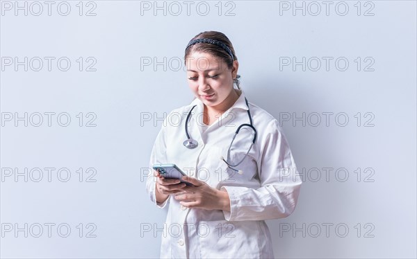 Young female doctor with telephone isolated. Smiling female doctor using phone on isolated background