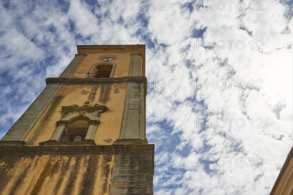 Frog's-eye view of a church tower with the facade in the foreground and cloudy sky, Novara di Sicilia, Sicily, Italy, Europe