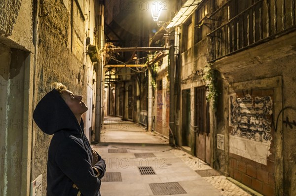 Lonely woman sightseeing the town at night, Coimbra