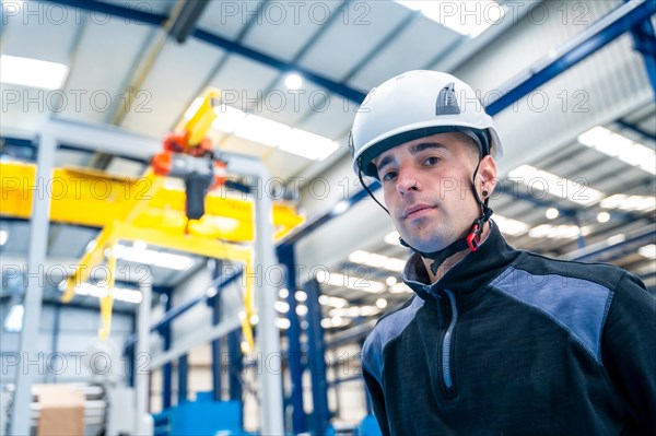 Close-up photo of a manual worker looking at camera wearing helmet