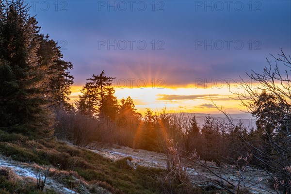 Landscape on the Grosser Feldberg, Taunus volcanic region. A cloudy, sunny winter day, meadows, hills, snow and forests with a view of the winter sunset. Hesse, Germany, Europe