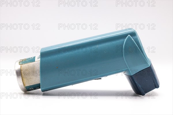 Blue asthma inhaler with blank label isolated on white background. Pharmaceutical product is used to treat or prevent asthma attack. Health and medical concept