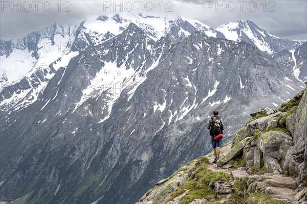 Mountaineer on hiking trail, glaciated rocky mountain peaks Hoher Weisszint, Berliner Hoehenweg, Zillertal Alps, Tyrol, Austria, Europe