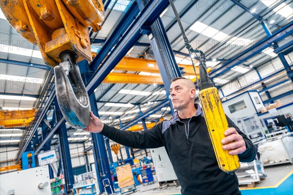 Worker using a huge industrial cane working in a logistics center