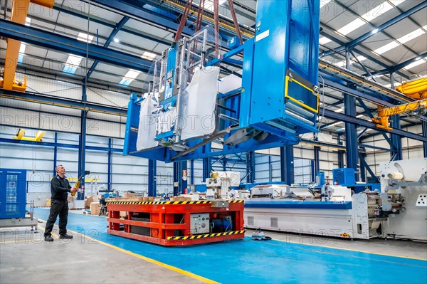 Horizontal photo with copy space of a crane lifting very heavy machinery in a factory