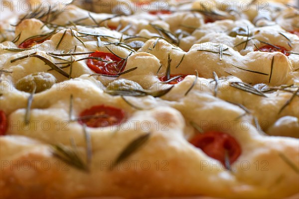 Homemade Italian flatbread Focaccia with cherry tomatoes, olives and rosemary