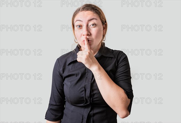 Amazed woman making silence gesture with finger. Blonde girl making silence gesture isolated