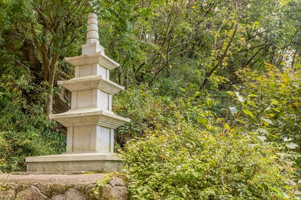 Concrete three story pagoda on concrete plinth in wilderness park