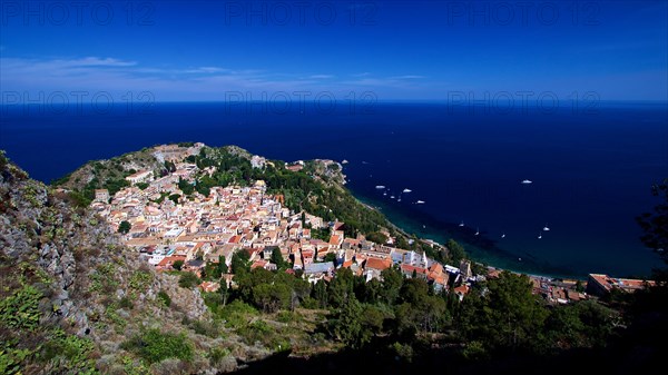 Panoramic view of a picturesque coastal town with historic architecture on the edge of the azure blue sea, boats on the sea, Taormina, Sicily, Italy, Europe