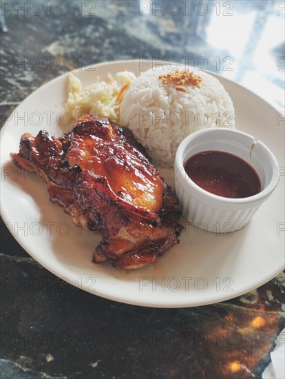 Chicken inasal with rice and atchara or papaya salad served with barbecue sauce, authentic Filipino food from the Philippines. Dipolog, Philippin