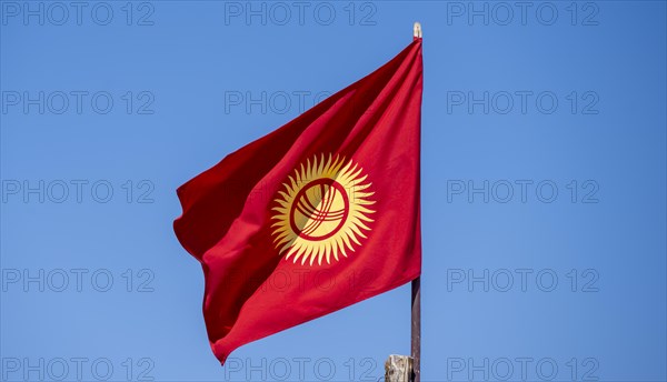 Kyrgyz national flag in front of a blue sky, Kyrgyzstan, Asia