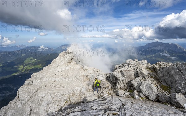 Climber on a via ferrata secured with steel rope, narrow rocky ridge, Watzmann crossing to Watzmann Mittelspitze, view of mountain panorama, Berchtesgaden National Park, Berchtesgaden Alps, Bavaria, Germany, Europe