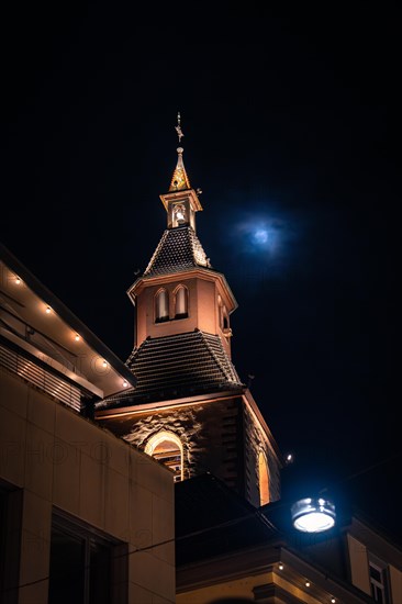 Illuminated church tower with the moon in the background at night, Nagold, Black Forest, Germany, Europe