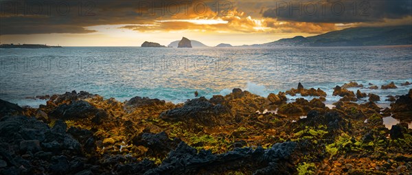 Dramatic volcanic coastal landscape at sunset with glowing sky and cliffs, Madalena, Pico, Azores, Portugal, Europe