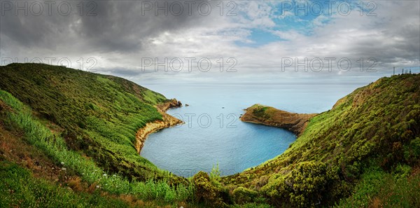 Panoramic view from Monte da Guia over a green coastline and bay on a cloudy day, Monte da Guia, Horta, Faial Island, Azores, Portugal, Europe