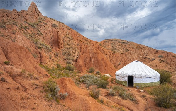 Yurt between eroded mountain landscape, sandstone rocks, canyon with red and orange rock formations, Konorchek Canyon, Chuy, Kyrgyzstan, Asia