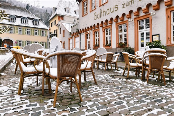 Heidelberg, Germany, February 2020: Empty tables with chairs covered in snow in front of outdoor restaurant in historic city center of Heidelberg during winter, Europe