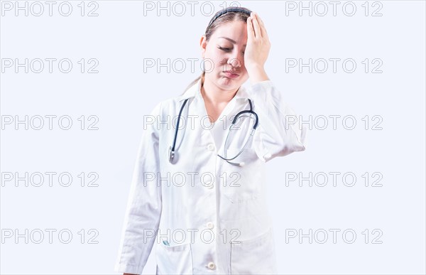 Exhausted female doctor with hand on forehead. Tired young female doctor with hand on forehead isolated