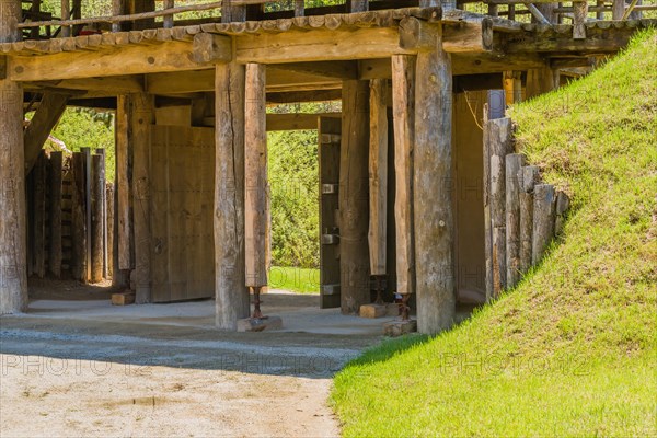 Wooden gate of traditional village made of logs and wooden planks with house jacks holding up support columns