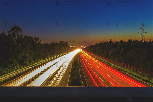 Long exposure of a busy motorway at dusk with glowing light trails of vehicles, A46 motorway, Haan, North Rhine-Westphalia, Germany, Europe
