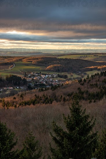 Landscape at the Grosser Zacken, Taunus volcanic region. A cloudy, sunny autumn day, meadows, hills, fields and forests with a view of the sunset. Hesse, Germany, Europe