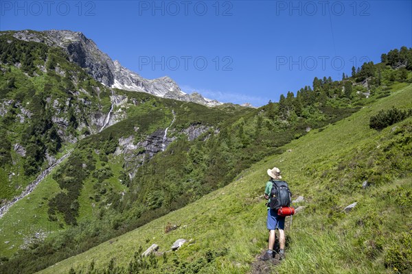 Mountaineer in front of mountain landscape, waterfalls of the Kesselbach, rocky mountain peaks, Berliner Hoehenweg, Zillertal Alps, Tyrol, Austria, Europe