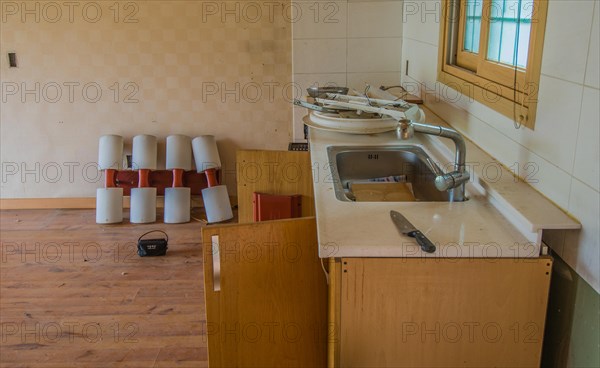 Daejeon, South Korea, June 29, 2018: Kitchen counter top of abandoned house with electrical fixtures on counter top and old newspapers in sink, Asia
