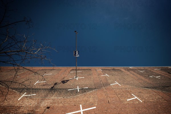 A lamppost and a car park sign in front of a brick wall with white lines, Cologne Deutz, North Rhine-Westphalia, Germany, Europe