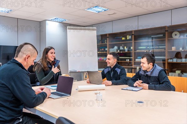 Group of engineers talking during a meeting in a fabric sitting together in a meeting room