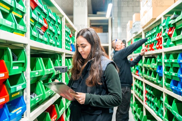 Two male and female warehouse and workers checking the inventory