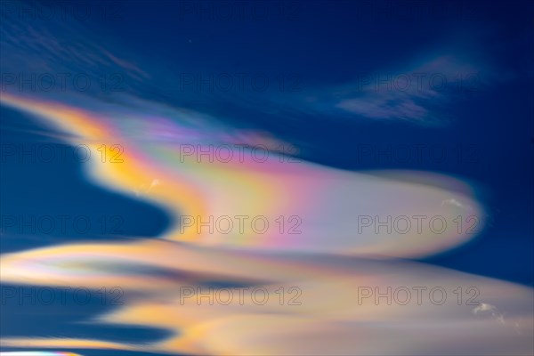 Beautiful Colorful Rainbow Clouds (Cloud Iridescence) Against Blue Sky in a Sunny Day with Light Effect in Lugano, Ticino, Switzerland, Europe