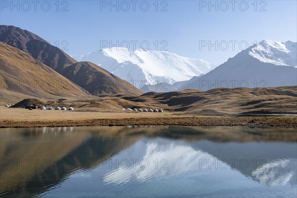 Yurts, mountains reflected in a small mountain lake, Pik Lenin, Trans Alay Mountains, Pamir Mountains, Osh Province, Kyrgyzstan, Asia