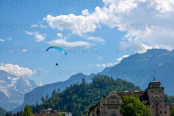 Paragliding in front Of Snow Capped Jungfraujoch Mountain in a Sunny Day in Interlaken, Bernese Oberland, Bern Canton, Switzerland, Europe