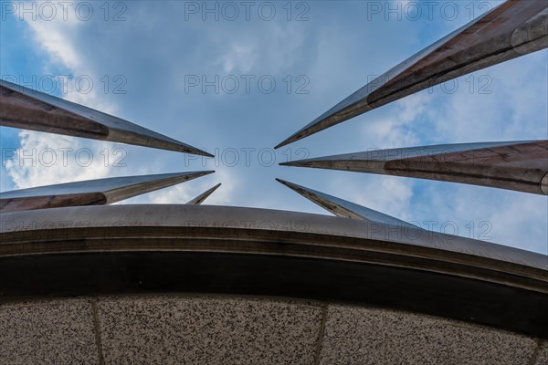 Curved, pointed spires of building reaching into beautiful partly cloudy blue sky