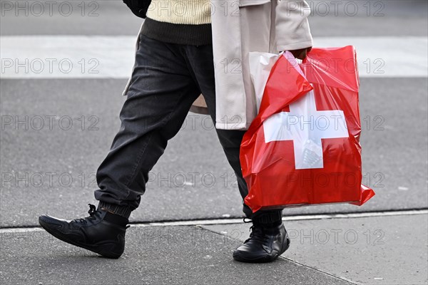 Man with plastic bag Swiss cross