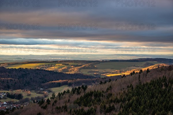 Landscape at the Grosser Zacken, Taunus volcanic region. A cloudy, sunny autumn day, meadows, hills, fields and forests with a view of the sunset. Hesse, Germany, Europe