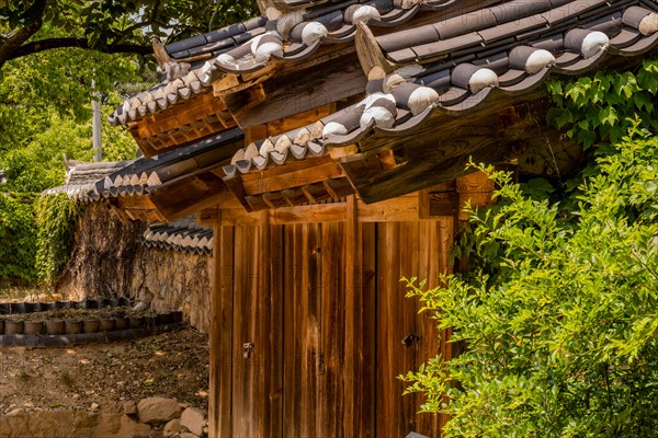 Ceramic tiles on roof of wooden gate located at public park displaying traditional Korean architecture