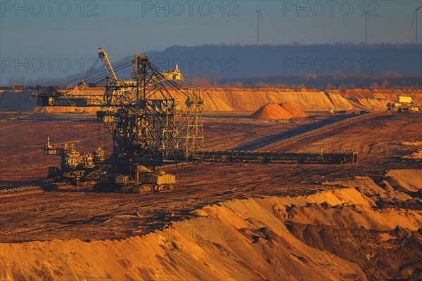 Large excavator in an open-cast mine with low sun and long shadows, open-cast lignite mine, North Rhine-Westphalia, Germany, Europe