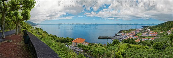Panoramic view of the picturesque coastal village of Ribeiras with lush vegetation under a soft blue sky, fishing village of Ribeiras, Pico Island, Azores, Portugal, Europe
