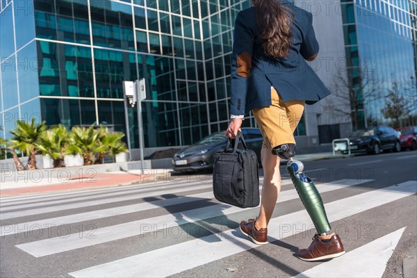 Rear view of a businessman with prosthetic leg in the city