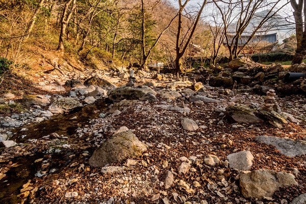 Pebble stacks in dry riverbed in mountain wilderness park