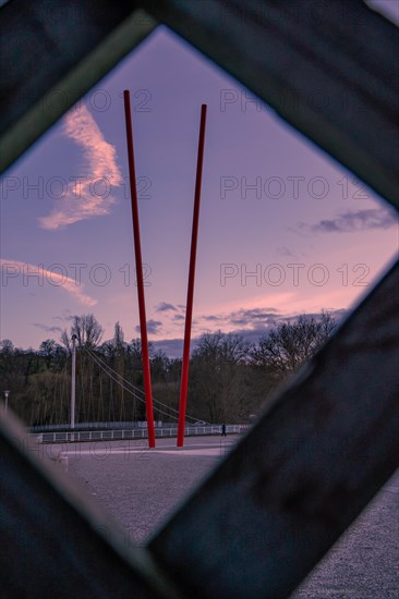 View through a frame of a red sculpture against a twilight sky, Enzauen Park, Pforzheim, Germany, Europe