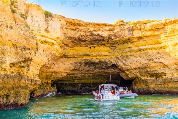 Albufeira, Portugal, May 28, 2022: Tourists in the boats sightseeing the caves on Algarve coast, Europe