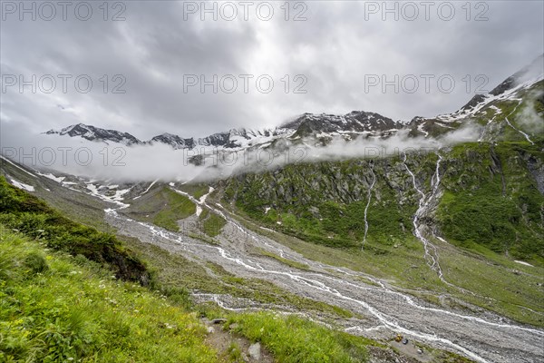 Cloudy valley of the Schlegeisgrund with mountain stream, glaciated mountain peaks Hoher Weiszint and glacier Schlegeiskees, Berliner Hoehenweg, Zillertal, Tyrol, Austria, Europe