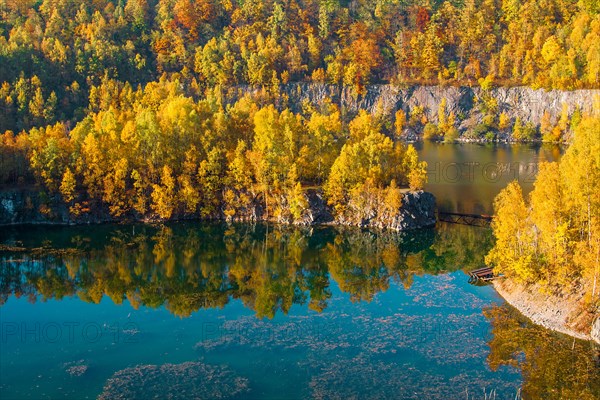 Autumn landscape with colourful trees on the shore of a lake next to a steep cliff, former Schlupkothen quarry, Wuelfrath, North Rhine-Westphalia, Germany, Europe