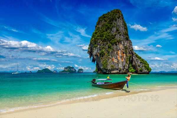 Long tail boat on tropical beach with limestone rock, Krabi, Thailand, Asia
